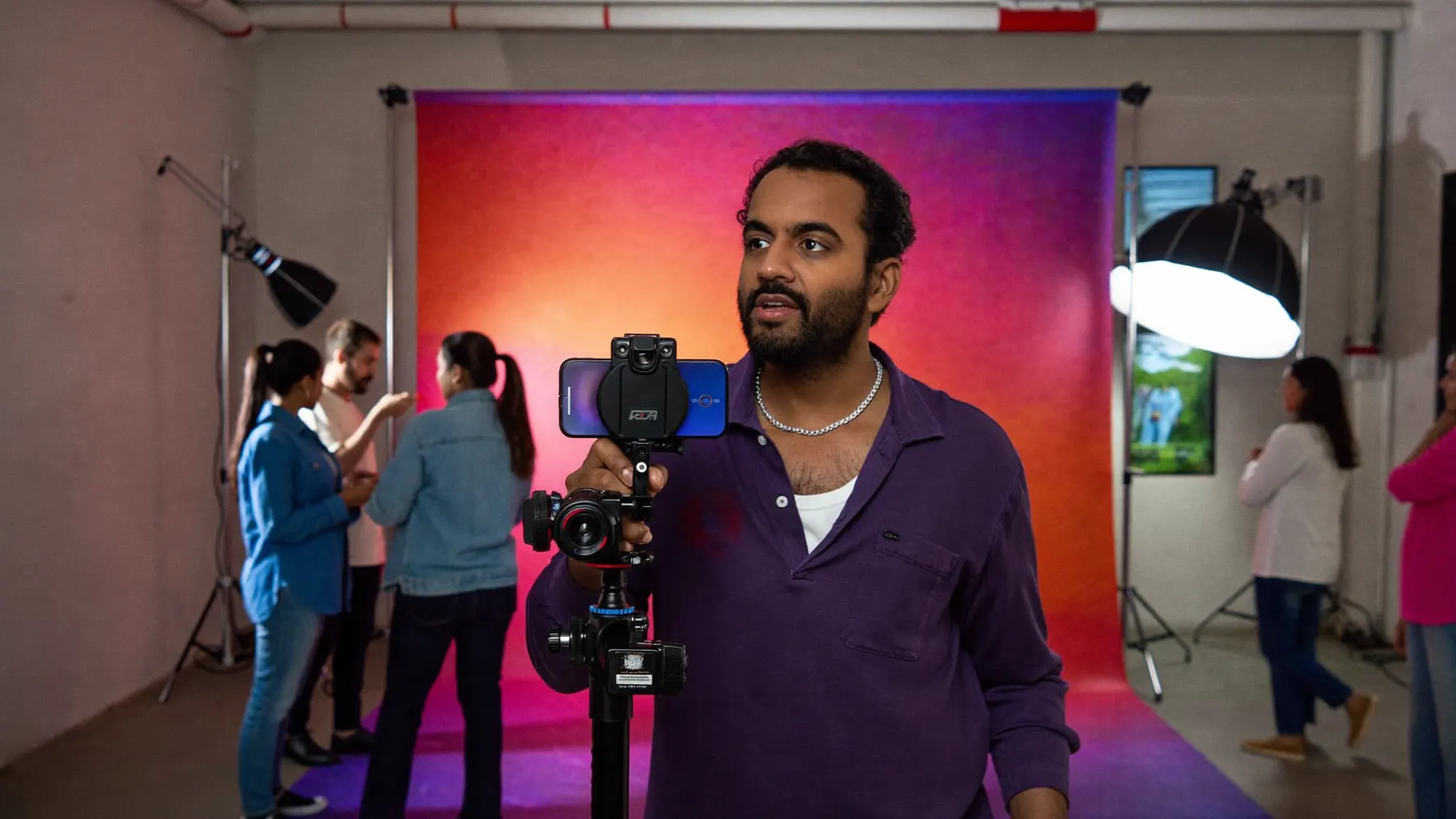 A creator filming a UGC ad on a gimbal in a colourful studio